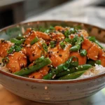 bowl of sesame chicken with green beans and rice