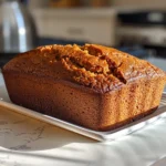 Close-up shot of a sliced Homemade Pumpkin Bread on a wooden cutting board.